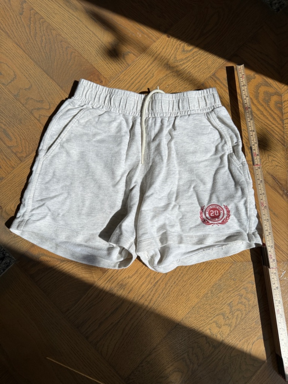 Light Gray Women’s Athletic Shorts with Red Crest Accent